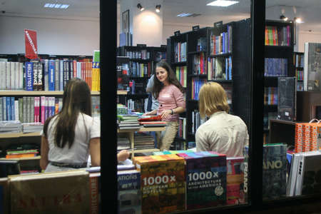 Bucharest, Romania, October 9, 2009: Women are seen through an window inside a book store in Bucharest.のeditorial素材