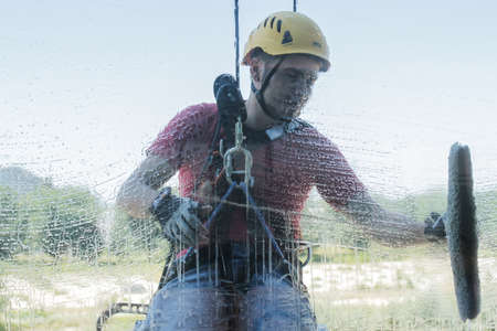 BUCHAREST, ROMANIA, June 16, 2016: Industrial climbers cleaning windows of an office building in Bucharest.のeditorial素材