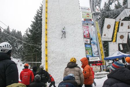 BUSTENI, ROMANIA, February 02, 2010: An ice climber on a frozen wall at competition in Busteni.のeditorial素材