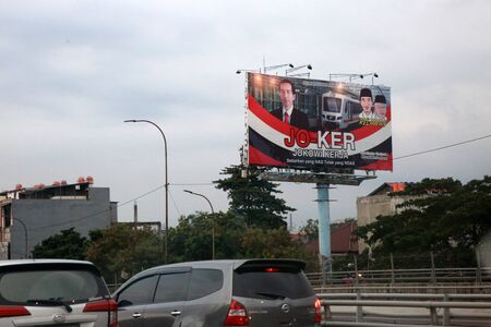 JAKARTA INDONESIA - March 29, 2019: Cars are passing near large election poster for Indonesian Presidential elections Jakarta, Indonesia.のeditorial素材