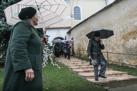 HARGHITA, ROMANIA - March 27, 2010: People going to church on a rainy day.のeditorial素材