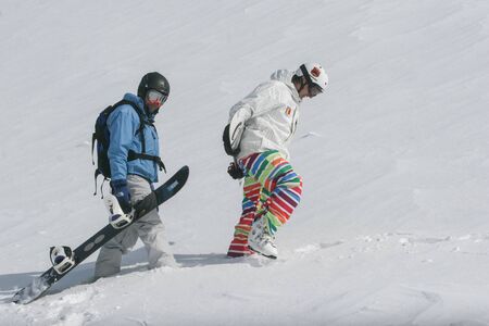 SIBIU, ROMANIA - March 13, 2010: A skier and a snowboader walks on the Fagaras mountainsのeditorial素材