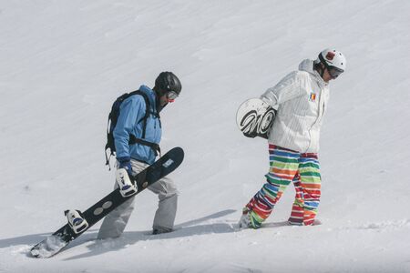 SIBIU, ROMANIA - March 13, 2010: Male snowboarder carrying his board walking in the Fagaras mountains.のeditorial素材
