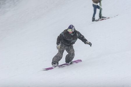 BUSTENI, ROMANIA - February 7, 2010: A man with a snowboard on the track.のeditorial素材