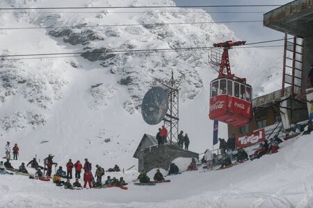 SIBIU, ROMANIA - March 13, 2010: Photo of cable way with Coca-Cola logo in Faragas mountains. Group of people having fun while skiing and snowboarding.のeditorial素材