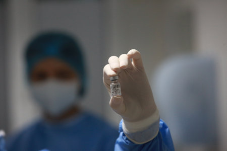 BUCHAREST, ROMANIA - Dec. 27, 2020: A nurse presents a dose of the Pfizer-BioNTech COVID-19 vaccine during the first day of European Vaccination Campaign.のeditorial素材