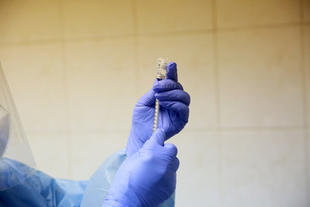 BUCHAREST, ROMANIA - Dec. 27, 2020: A nurse prepares a dose of the Pfizer-BioNTech COVID-19 vaccine during the first day of European Vaccination Campaign.のeditorial素材