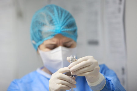 BUCHAREST, ROMANIA - Dec. 27, 2020: A nurse prepares a dose of the Pfizer-BioNTech COVID-19 vaccine during the first day of European Vaccination Campaign.のeditorial素材