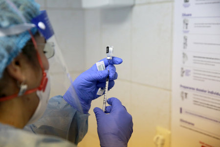 BUCHAREST, ROMANIA - Dec. 27, 2020: A nurse prepares a dose of the Pfizer-BioNTech COVID-19 vaccine during the first day of European Vaccination Campaign.のeditorial素材