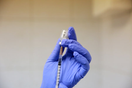 BUCHAREST, ROMANIA - Dec. 27, 2020: A nurse prepares a dose of the Pfizer-BioNTech COVID-19 vaccine during the first day of European Vaccination Campaign.のeditorial素材