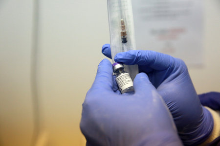 BUCHAREST, ROMANIA - Dec. 27, 2020: A nurse presents a dose of the Pfizer-BioNTech COVID-19 vaccine during the first day of European Vaccination Campaign.のeditorial素材