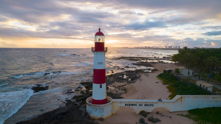 Aerial view of Itapua Lighthouse at sunset with rocks and seaの写真素材