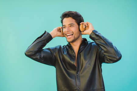 Candid man listening to song from wireless headsetの写真素材
