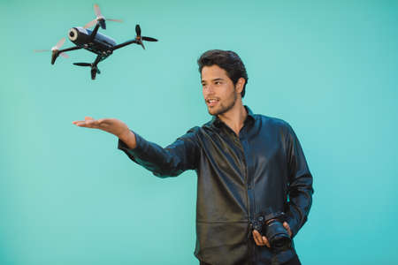 Masculine man with digital photo camera and flying droneの写真素材