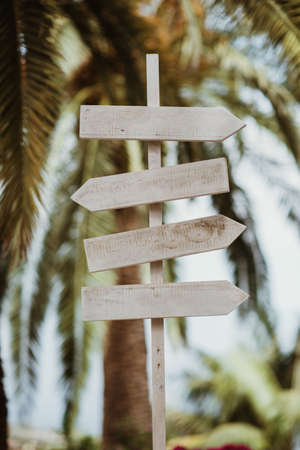 Close-up of a wooden sign in a park with several arrows indicating various directions.