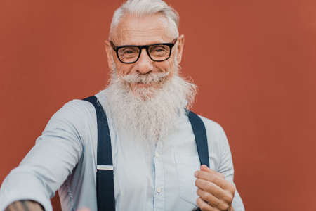 Happy senior man looking at camera wearing modern clothes and glassesの写真素材