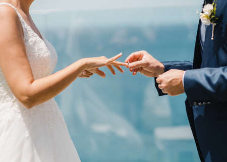 Crop newlyweds exchanging wedding rings during ceremonyの写真素材
