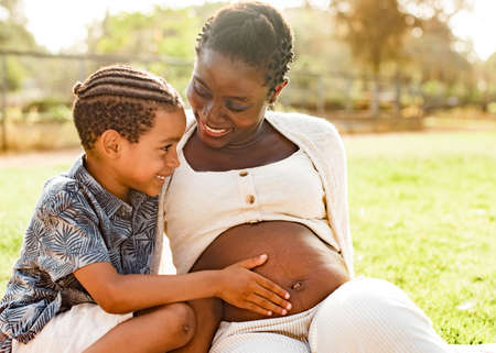 Black boy touching tummy of pregnant woman