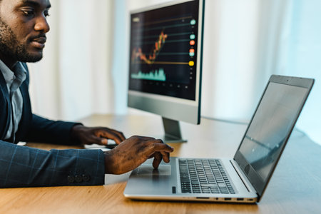 Focused male trader using laptop