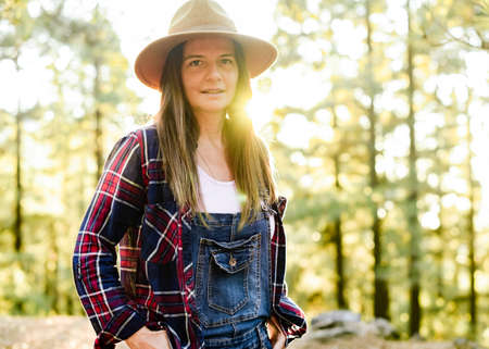 Content traveler standing in woods in autumn