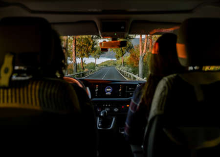 Unrecognizable traveler driving along road
