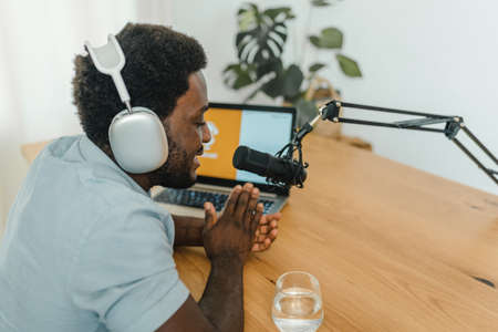 Content black man recording podcast in studioの写真素材