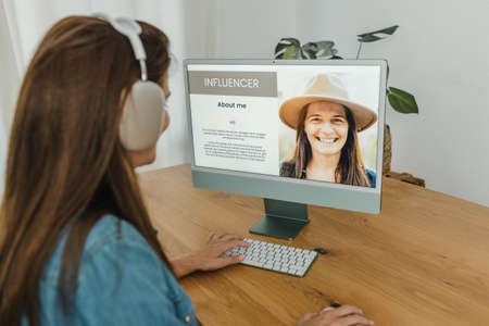 Female influencer using computer and browsing blogの写真素材