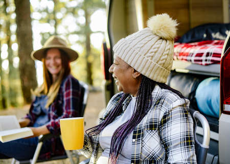 Black woman near van against blurred friend