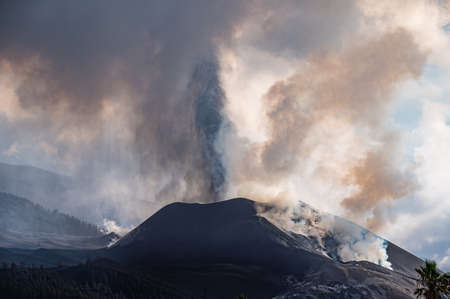 Active volcano with thick smoke erupting in daytimeの写真素材