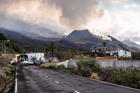 Small houses located in countryside against active volcano in daytimeの写真素材
