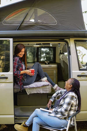 Diverse traveling women near van at campsiteの写真素材