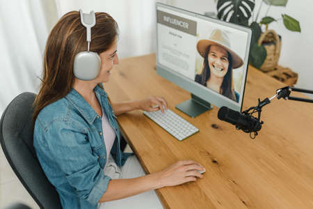 Radio host recording podcast and using computer