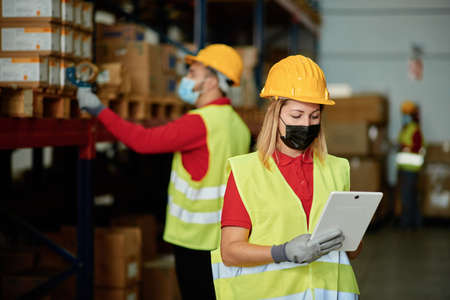 Workers in protective masks using tablet