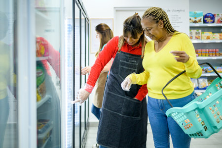 Seller helping Hispanic woman to choose productsの写真素材