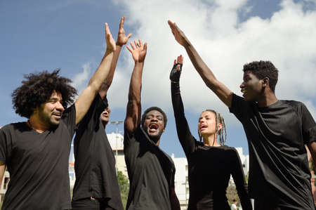 Cheerful African American basketball team giving high five in cityの写真素材