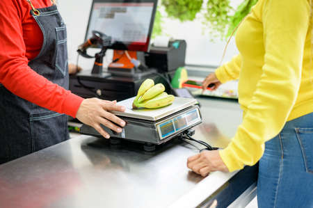 Crop seller weighing bananas for customer