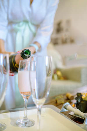 Faceless woman pouring champagne into wineglassの写真素材