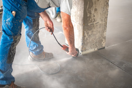 Crop worker cutting concrete with angle grinderの写真素材