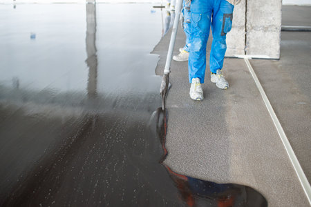 Crop masters pouring liquid concrete on floor at construction siteの写真素材