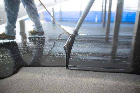 Crop unrecognizable people pouring concrete on floorの写真素材