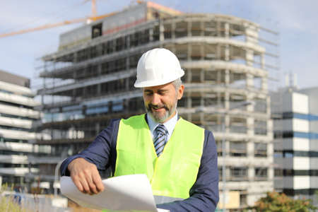 senior architect in front of buildingの写真素材