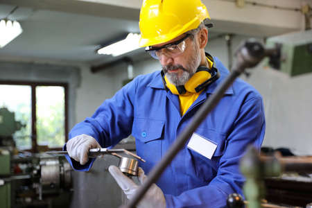 Man operating lathe grinding machineの写真素材