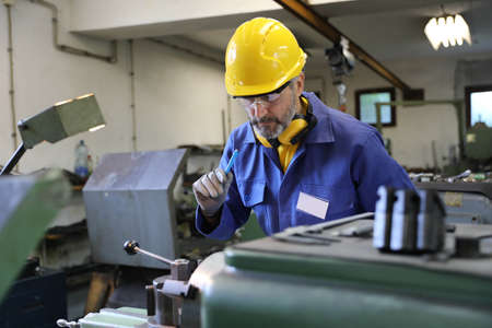 Man operating lathe grinding machineの写真素材