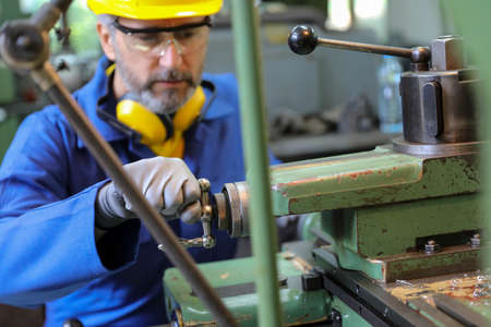 Man operating lathe grinding machineの写真素材