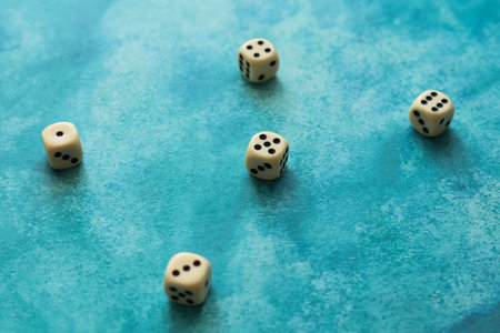 cream color dice on a blue watercolor backgroundの写真素材