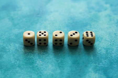 cream color dice on a blue watercolor backgroundの写真素材