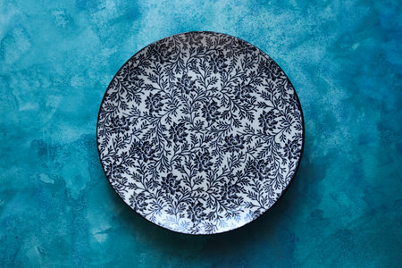 porcelain plate with a floral pattern on a blue watercolor backgroundの写真素材