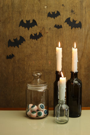 halloween still life with black paper bats and burning candlesの写真素材