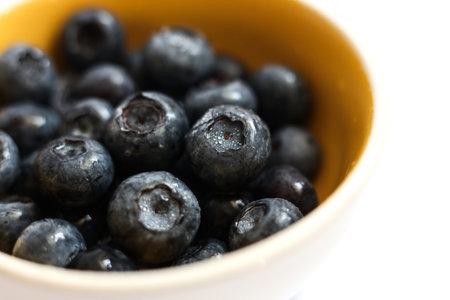 and macro selective focus blackberries in a bright yellow bowlの写真素材