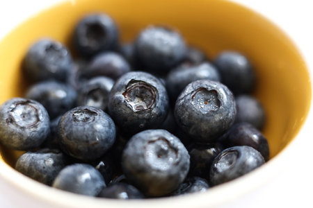 and macro selective focus blackberries in a bright yellow bowlの写真素材